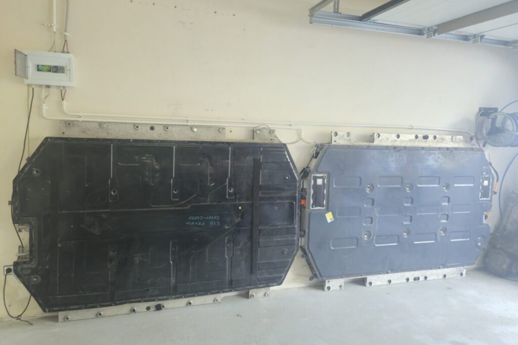 Twee EV-batterijen aan de muur van een garage, samen gebruikt als thuisbatterij van 151 kWh